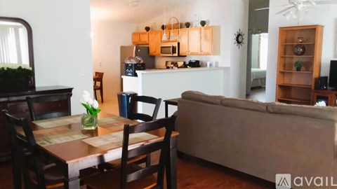 A dining table with chairs and a couch in a living room.