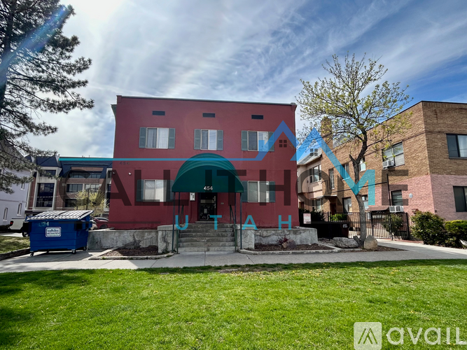 A red building with a green awning and a sign that says "A H" in front of it.