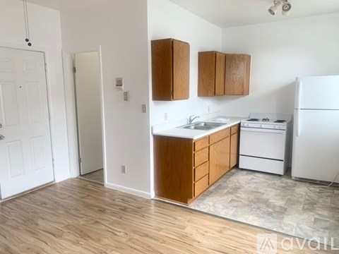 A kitchen with white appliances and wooden cabinets.