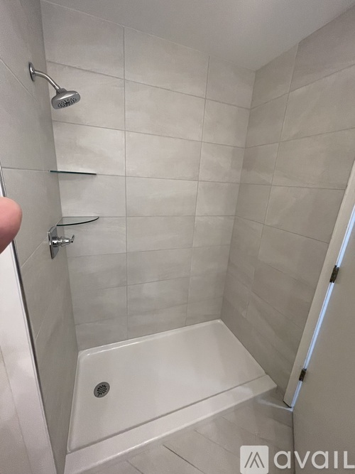A shower area with a drain in the tub.