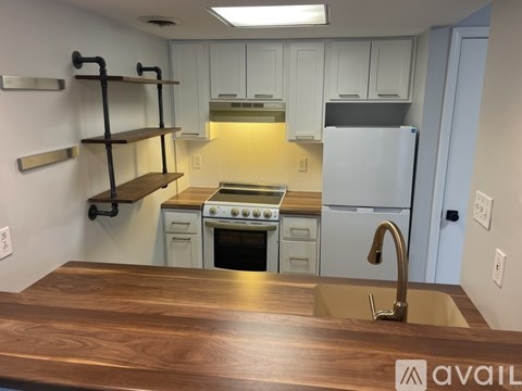 A kitchen with a wooden counter top and white cabinets.