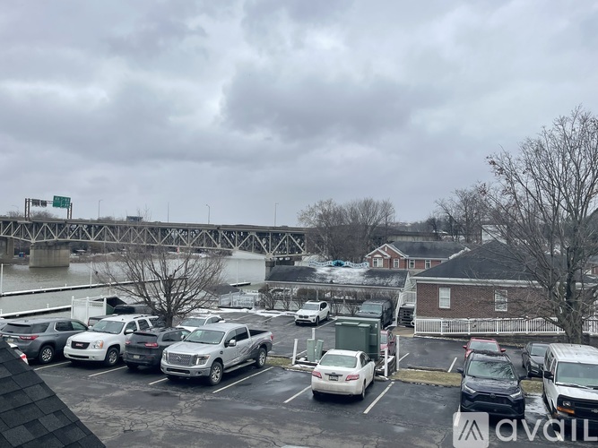 A parking lot with cars and a bridge in the background.