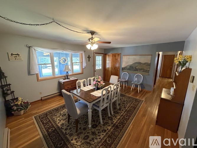 A dining room with a wooden table and chairs.