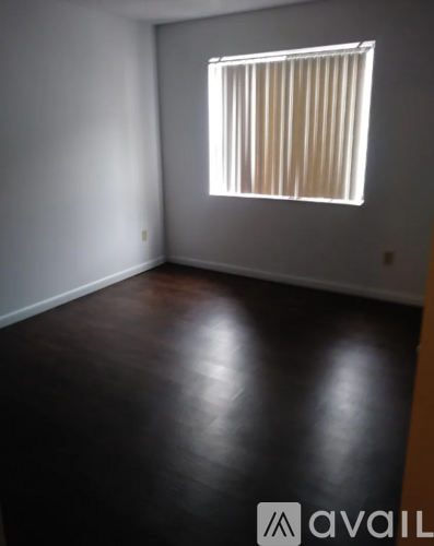 A room with a window and wooden floors.