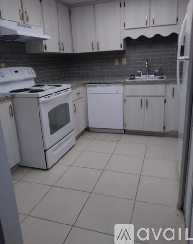 A kitchen with white appliances and cabinets.
