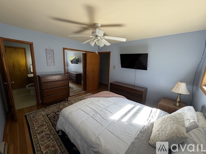A bedroom with a large bed and a ceiling fan.