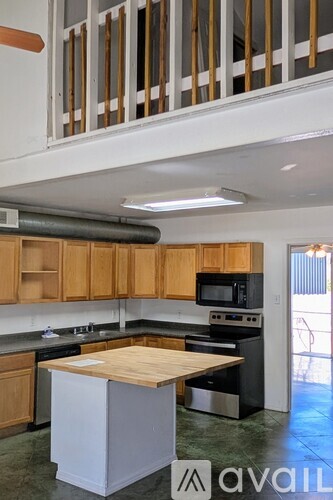 A kitchen with wooden cabinets and a white island.
