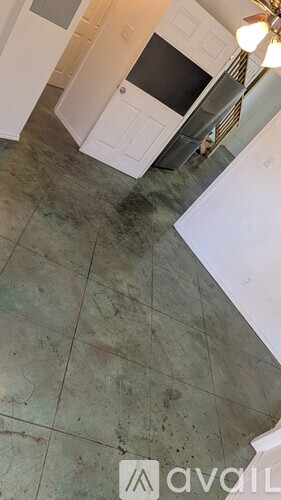 A kitchen with a tile floor and a ceiling fan.