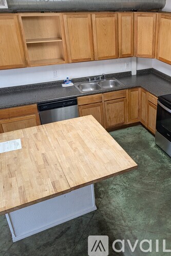 A kitchen with wooden cabinets and a wooden table.