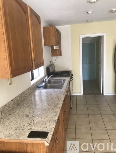 A kitchen with wooden cabinets and granite countertops is available.