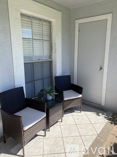 A patio with a white door and a table with two chairs.