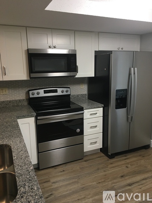 A kitchen with a stove, microwave, and refrigerator.