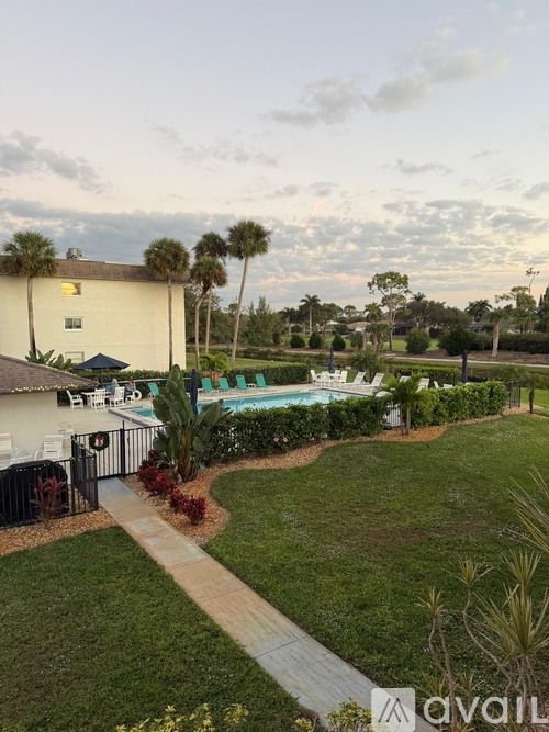 A backyard with a pool and a walkway.