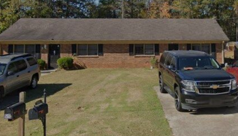 A black SUV is parked in front of a house.