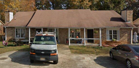 A house with a van and a car parked in front.