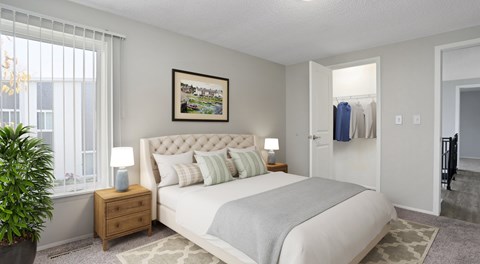 A bedroom with a large bed, a nightstand with a lamp, and a painting on the wall.