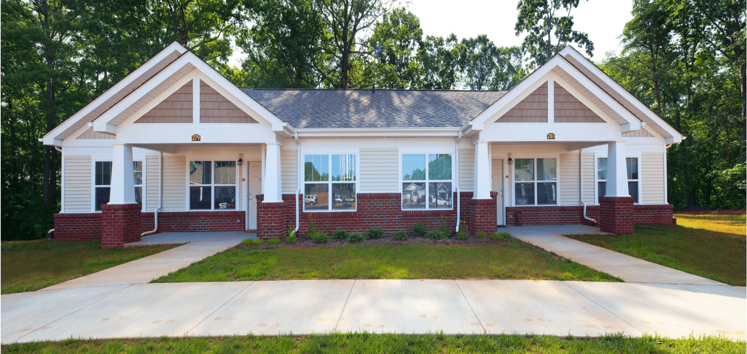A house with a red brick base and white walls.