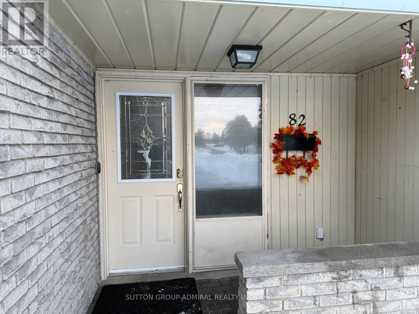 A white door with a glass window and a wreath on the door.