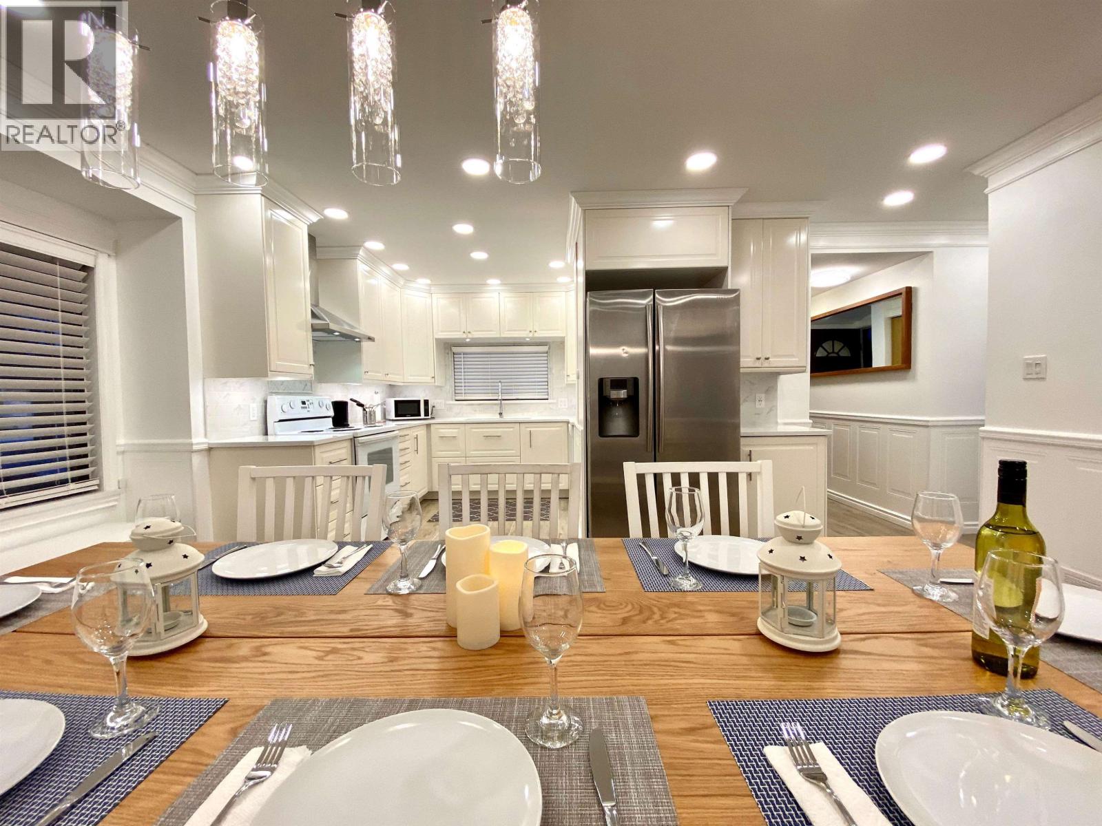 A dining room with a table set for a meal.
