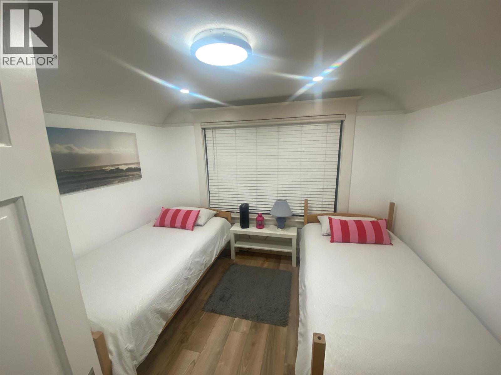 A bedroom with two beds and a ceiling light.