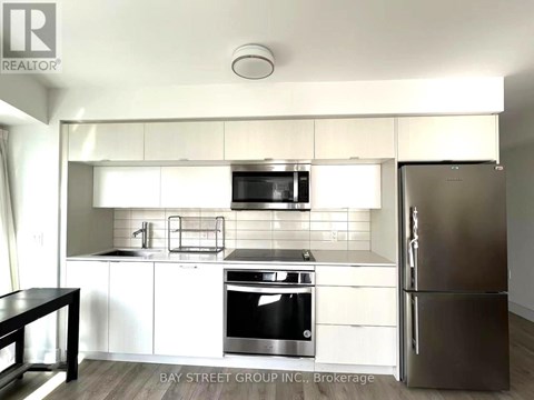 A modern kitchen with white cabinets and stainless steel appliances.