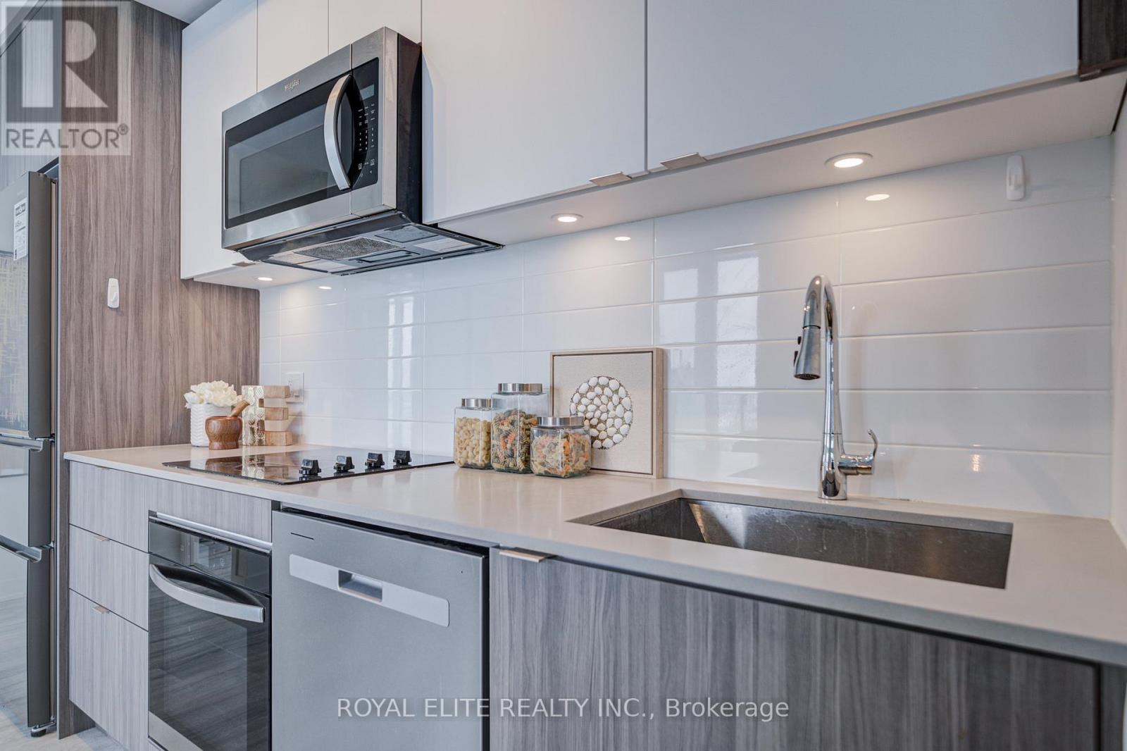 A modern kitchen with a stainless steel oven and microwave above the counter.