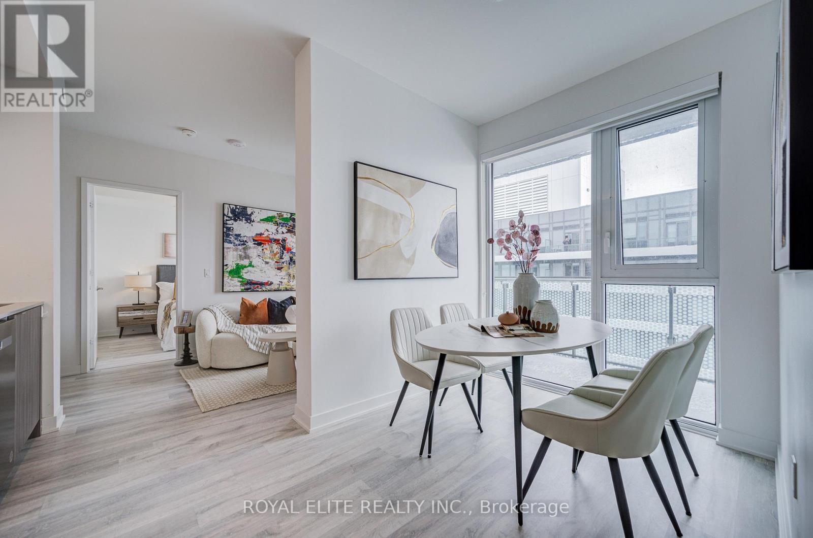 A modern dining room with a white table and chairs.