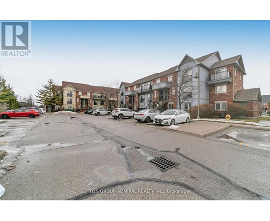 A parking lot with cars and a building in the background.