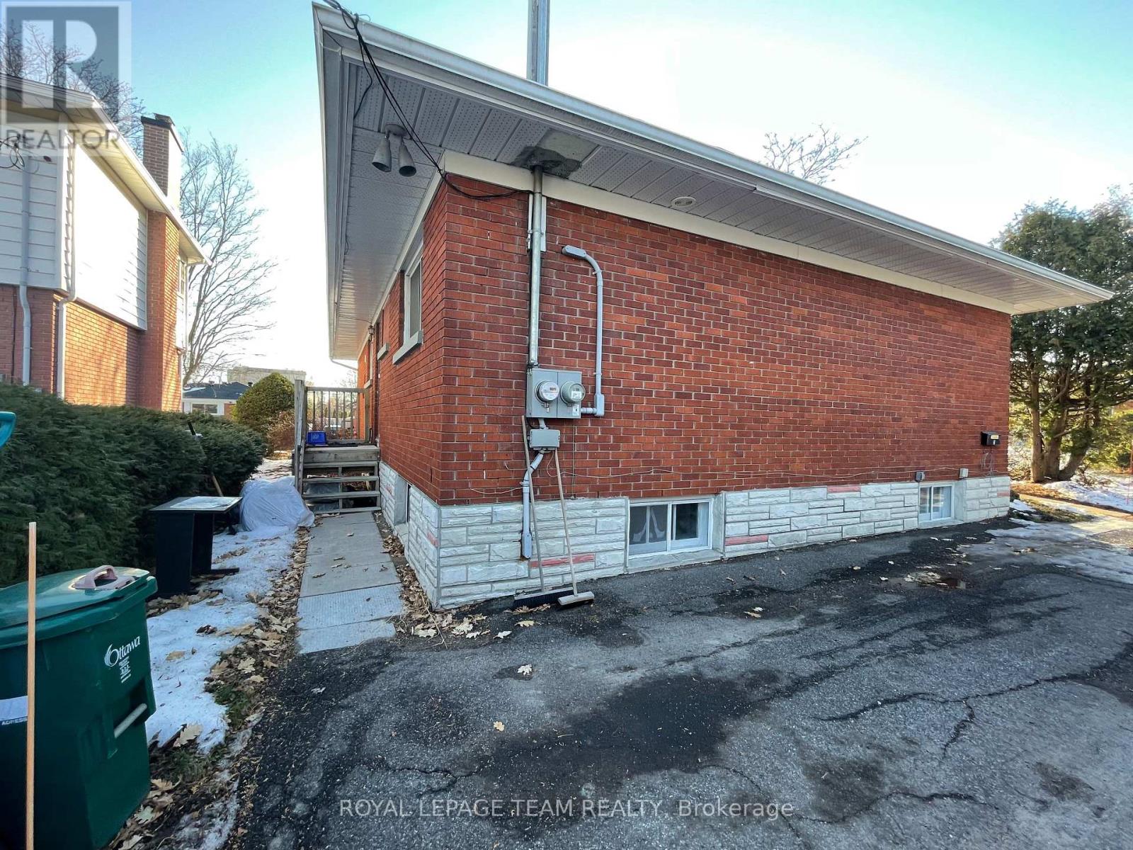 A red brick building with a white roof and a white garage door.