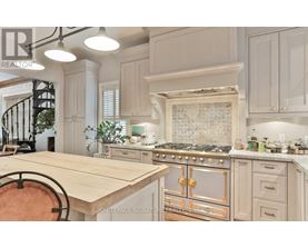 A kitchen with a wooden table and a stove with a gold handle.
