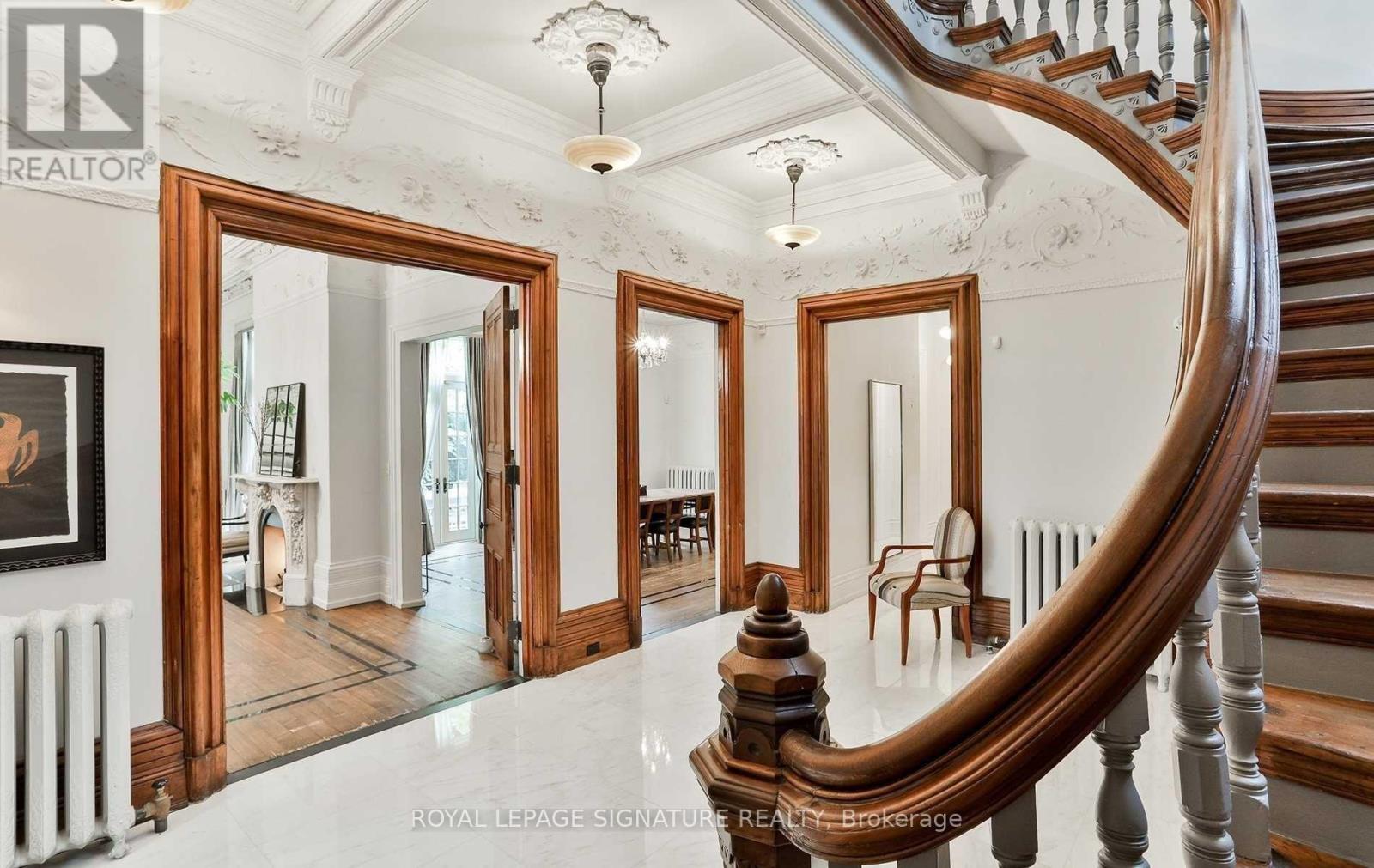 A spacious foyer with a curved staircase and a large mirror.