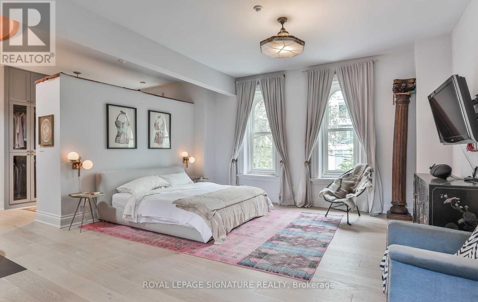 A bedroom with a large bed and a television.