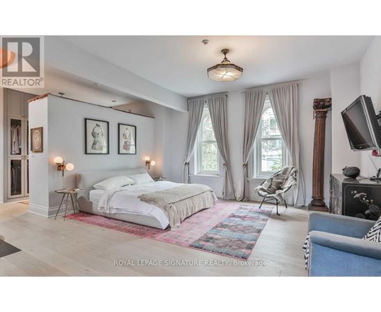 A bedroom with a large bed and a television.