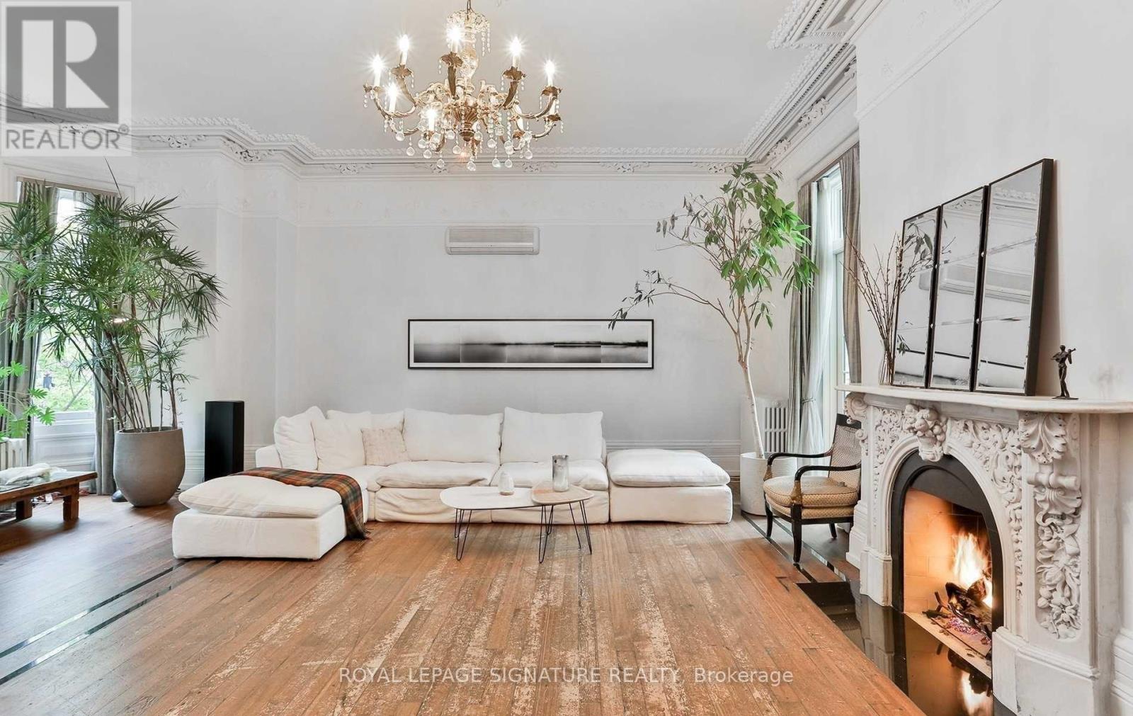 A living room with a fireplace and a large painting on the wall.