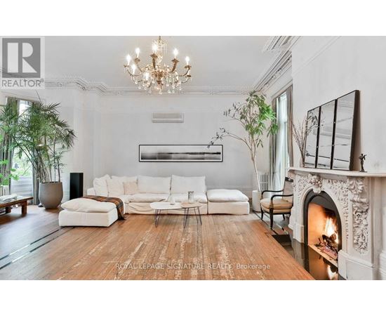 A living room with a fireplace and a large painting on the wall.