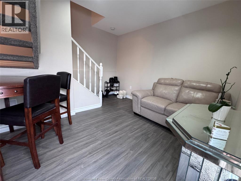 A living room with a couch, chair, and a glass table.