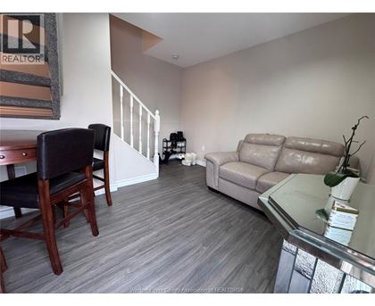 A living room with a couch, chair, and a glass table.