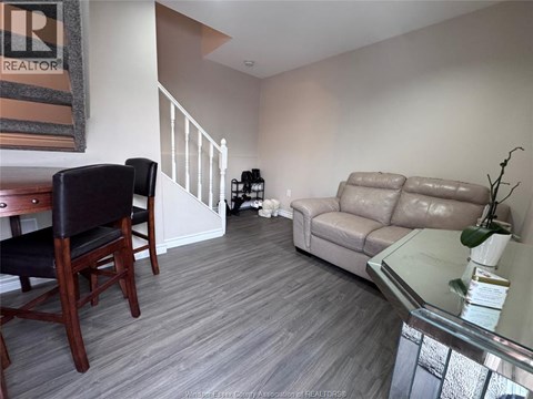 A living room with a couch, chair, and a glass table.