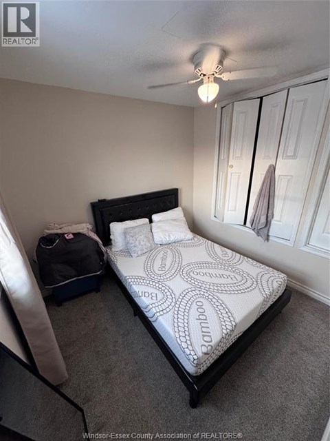 A bedroom with a bed, a suitcase, and a bag on the floor.