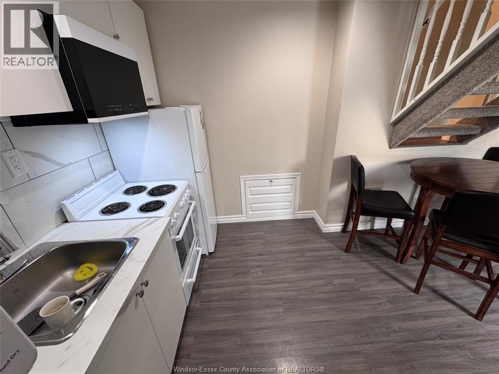 A kitchen with a stove top oven and a sink.