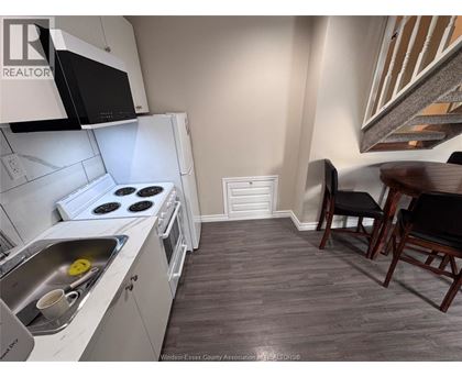 A kitchen with a stove top oven and a sink.