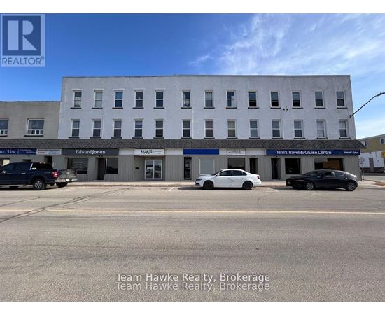 A building with the sign Team Hawke Realty Brokerage in front of it.