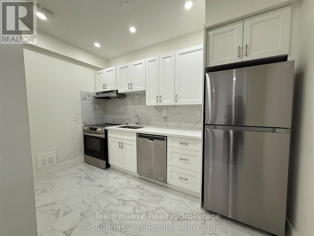 A kitchen with white cabinets and a marble floor.