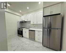 A kitchen with white cabinets and a marble floor.