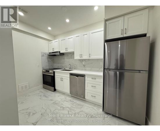 A kitchen with white cabinets and a marble floor.