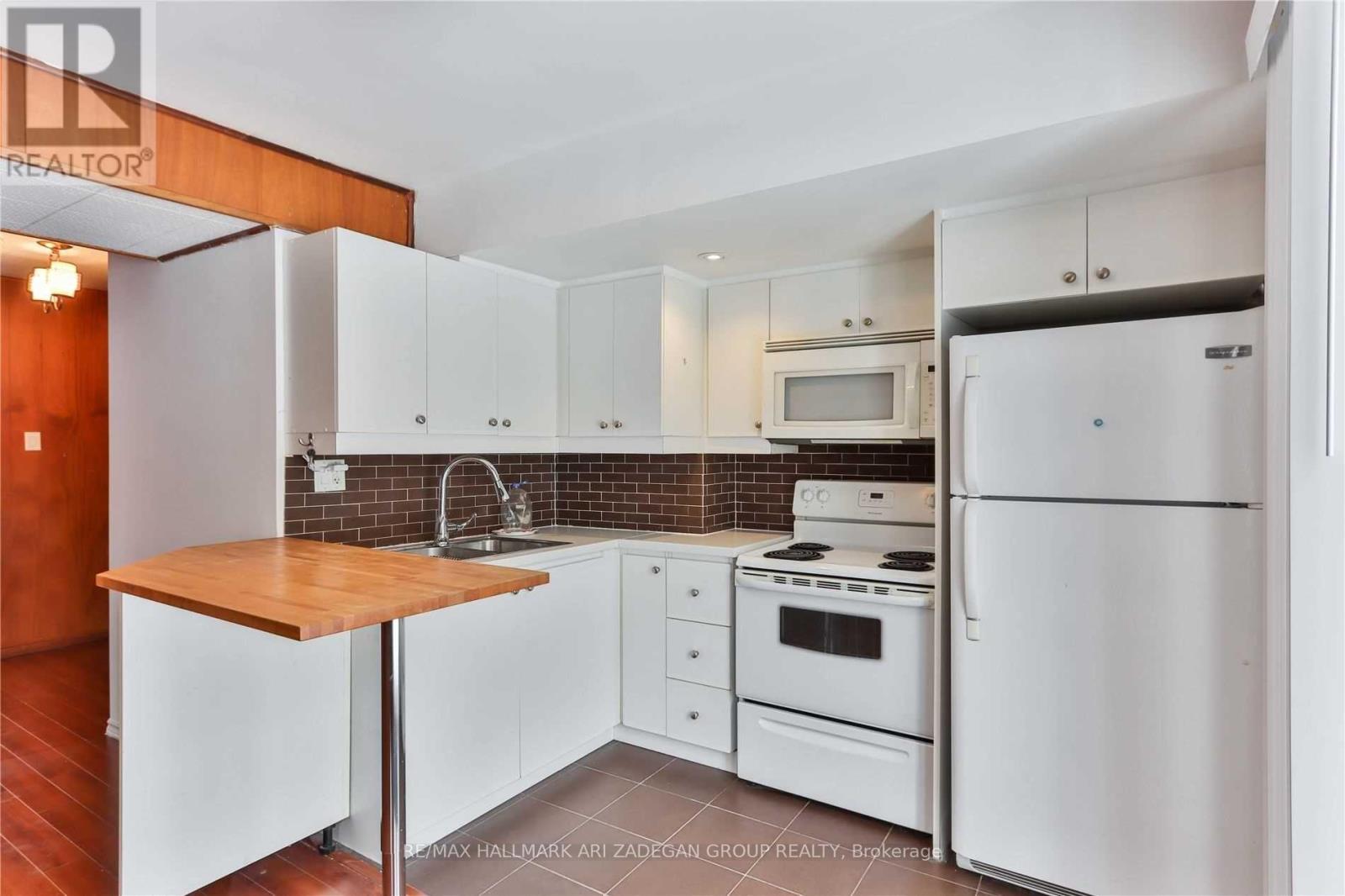 A kitchen with white appliances and cabinets.
