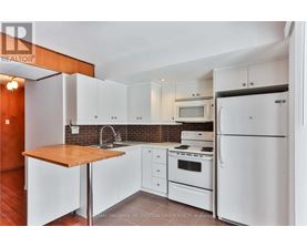 A kitchen with white appliances and cabinets.