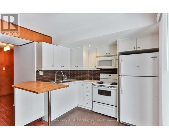 A kitchen with white appliances and cabinets.