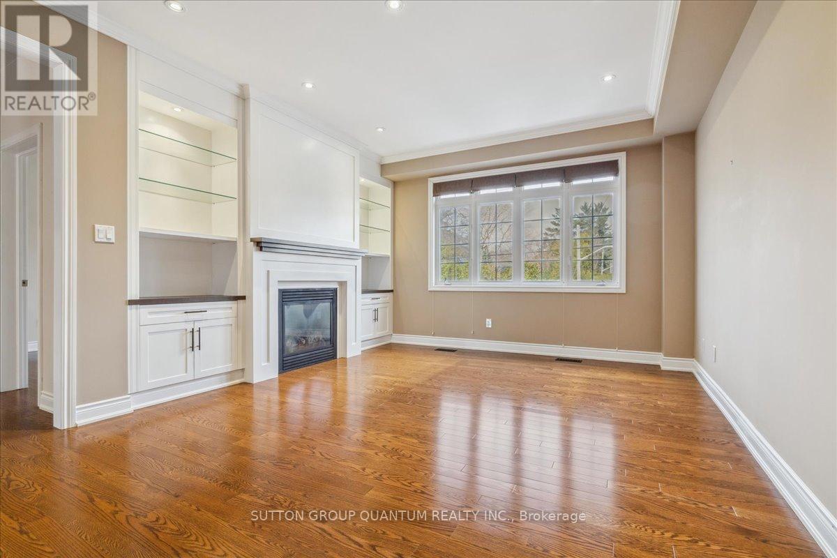 A spacious room with wood flooring and a fireplace.