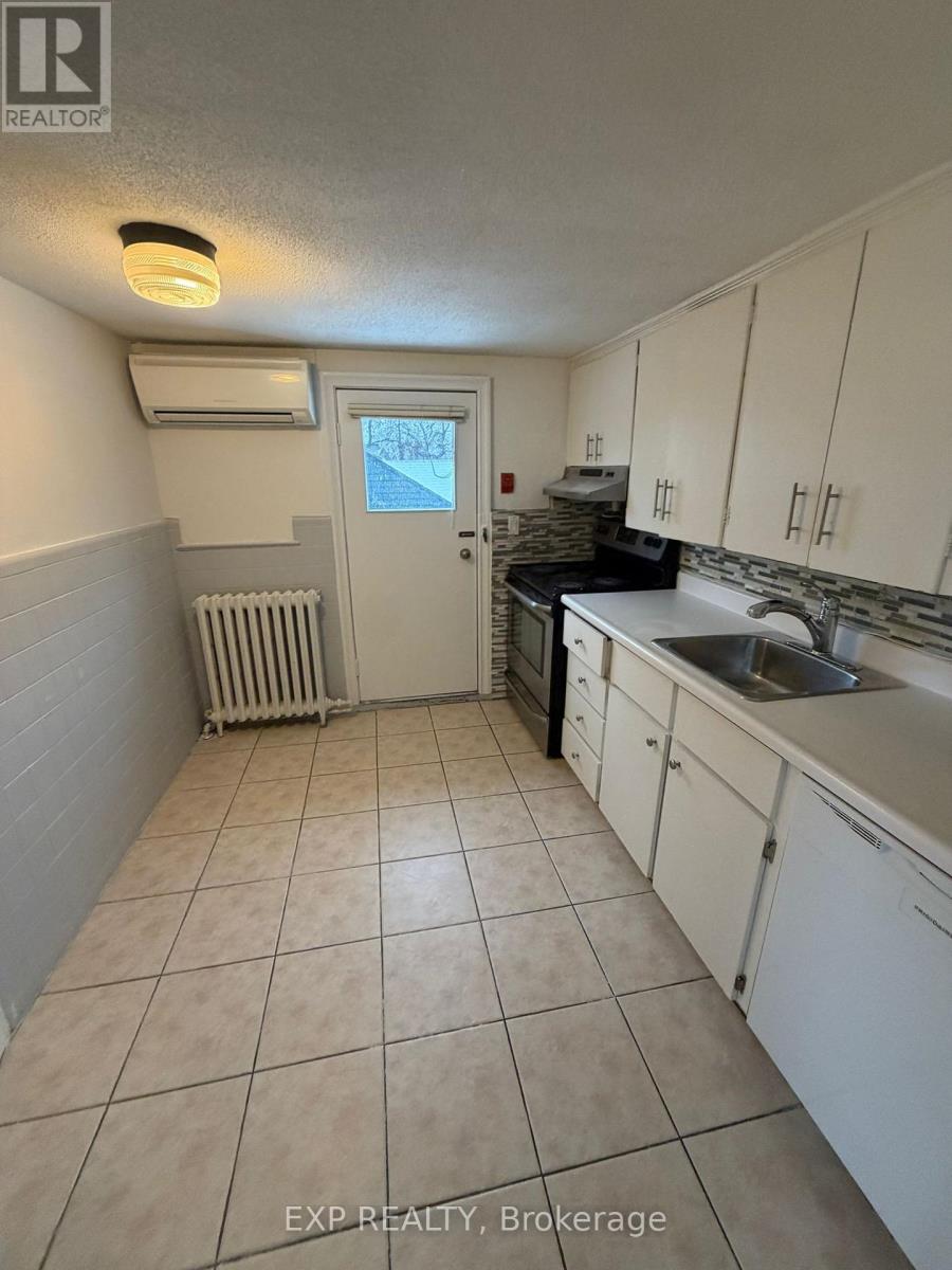 A kitchen with white cabinets and a tiled floor.